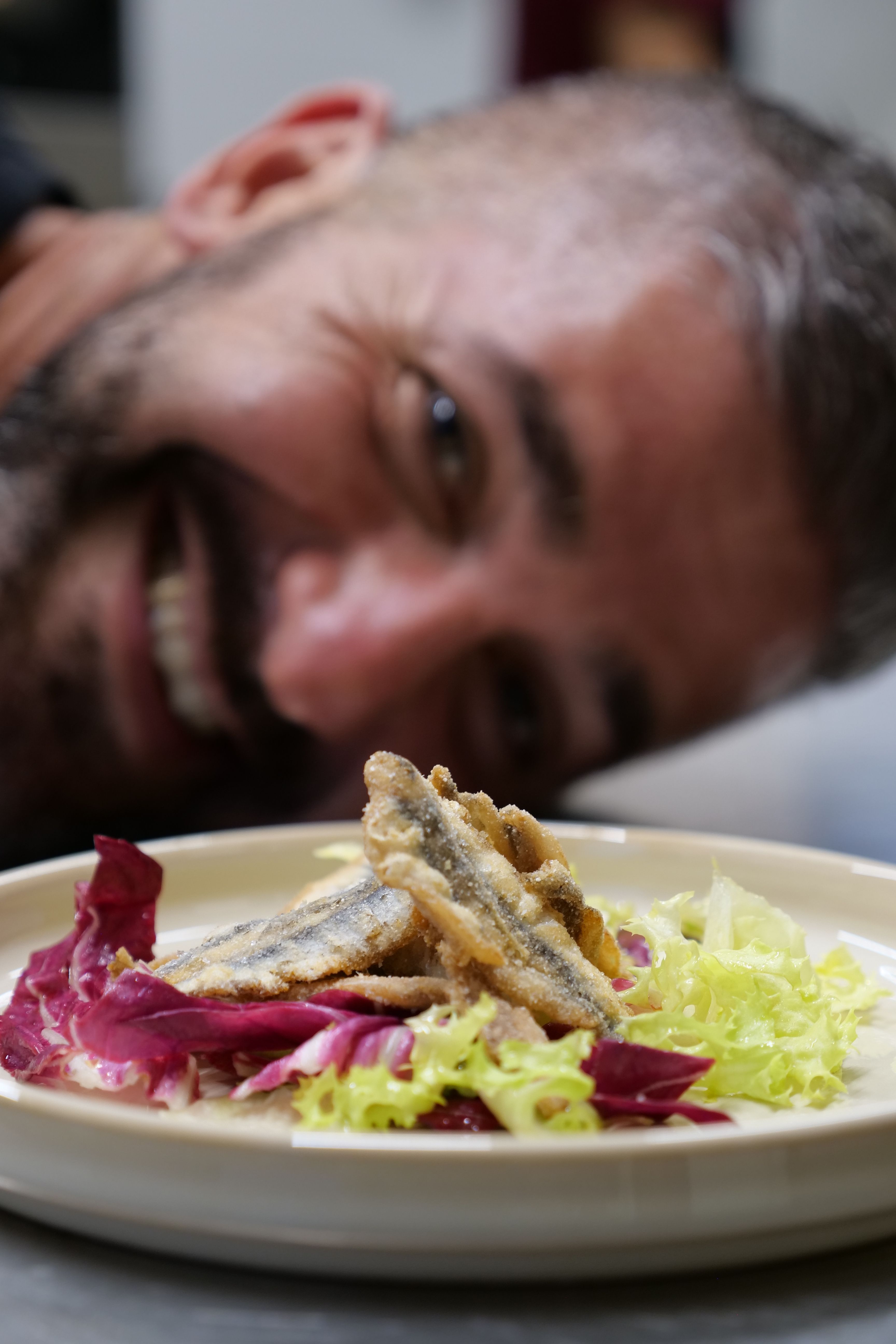 cuoco che sorride dietro piatto di alici fritte Agriturismo cena degustazione in cantina Tenuta Trium a Notaresco di Teramo